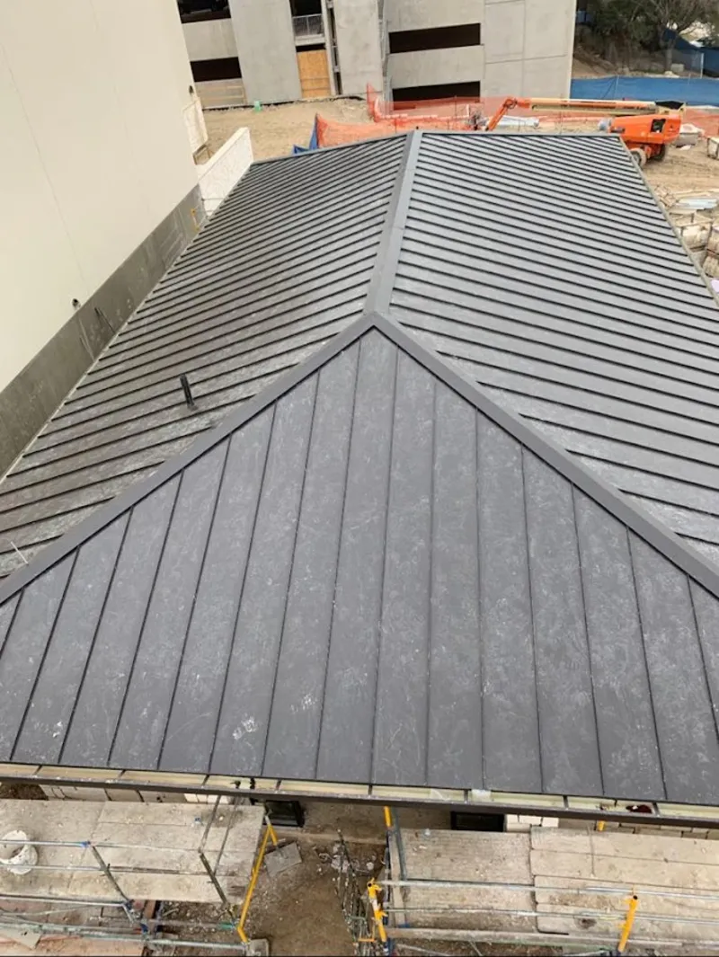 Commercial metal roof construction with crane equipment in Moses Lake